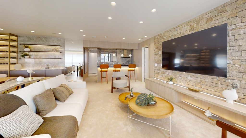 Imagem de uma sala de estar ampla e decorada, com uma televisão, sofá, bancada, mesa de jantar e outros móveis em estilo minimalista, no AYA, empreendimento de alto padrão em Guarulhos